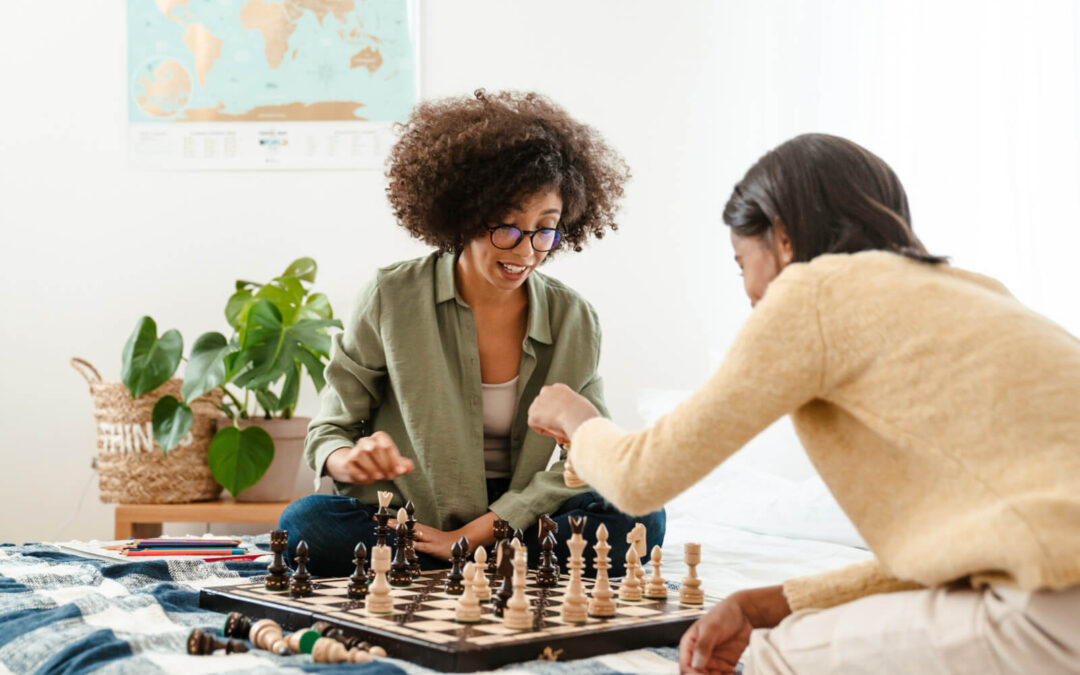 Woman plays chess at home with her daughter